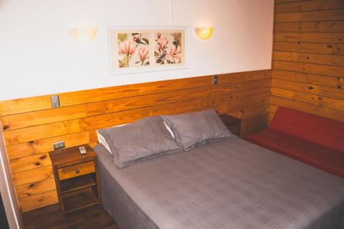 a bedroom with a bed and a wooden wall at Cabañas Entremar in Pichilemu