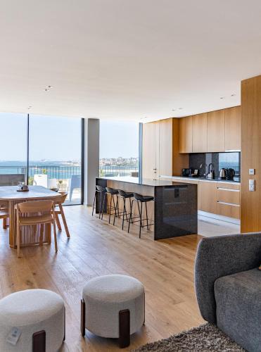 an open kitchen and living room with a table and chairs at Bellevue | Sea & River View | Garage in Canidelo