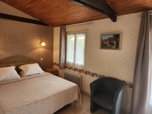 a bedroom with a bed and a chair and a window at Le chalet des Contries in Sarlat-la-Canéda