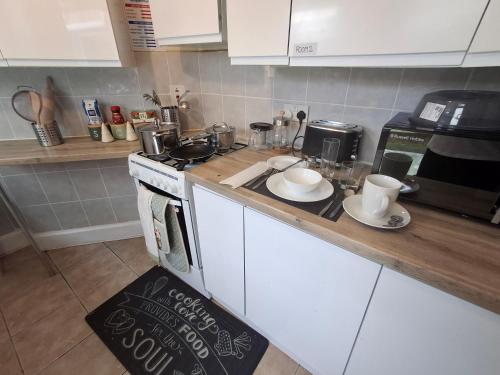 y cocina con encimera, fogones y microondas. en Peacock Quarters, en Croydon
