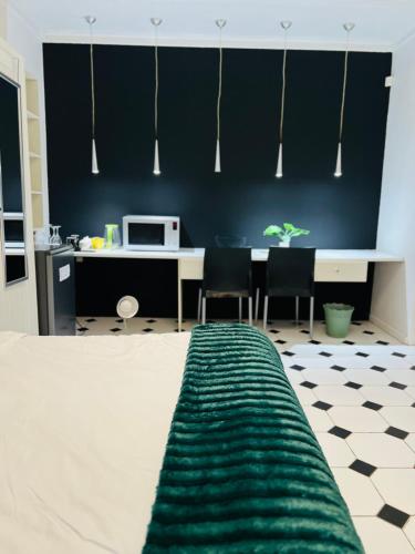 a room with a desk with chairs and a microwave at Mekenificent Stays in Windhoek
