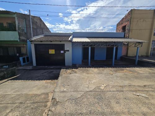 a small blue building with a garage at Flat completo a 10 minutos de vários espaços de festa in Aparecida de Goiania