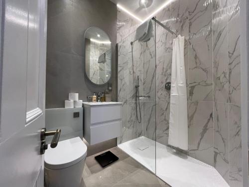 a bathroom with a shower and a toilet and a sink at 4-Bedroom Apartment – Sleeps 7 – Paddington – Quiet Area in London