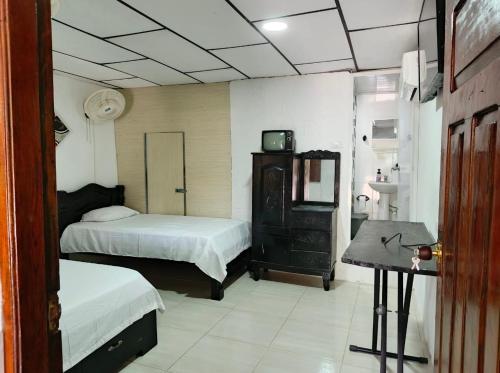 a room with two beds and a desk in it at Casa S&J in Mompos