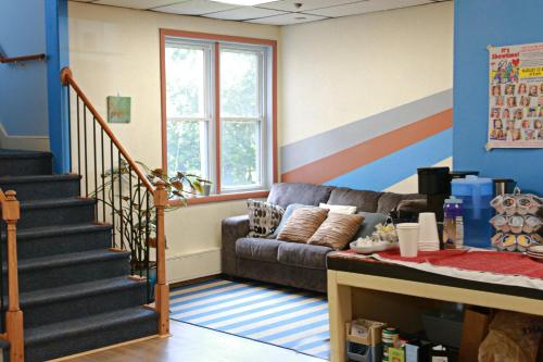 a living room with a couch and a staircase at Foothills Lodge & Diner in Malone