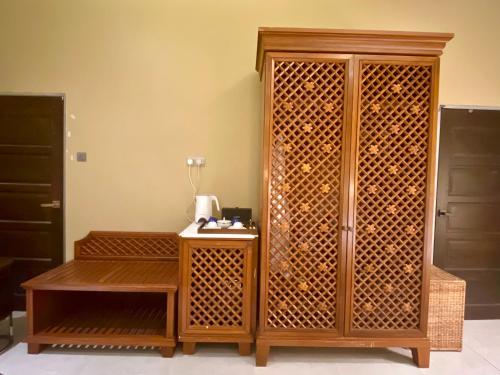 a wooden cabinet with a table in a room at Landmark Cenang in Pantai Cenang