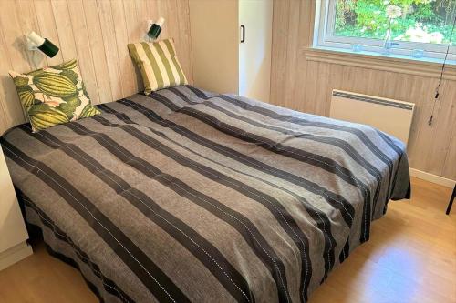 una camera da letto con un letto con una coperta a righe e una finestra di 40893-Ulfborg-Skindbjergvej-393 a Fjand Gårde