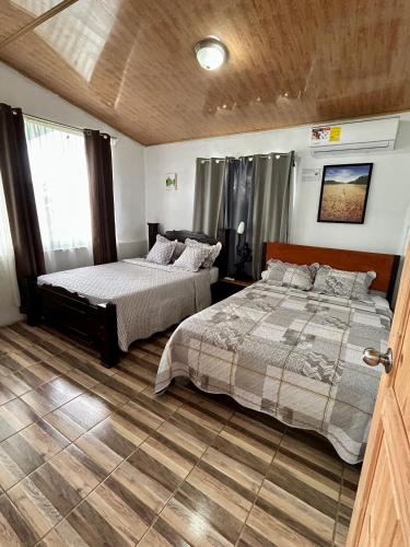 a bedroom with two beds and a window at Vista al Volcán Tenorio y Montaña in San Rafael