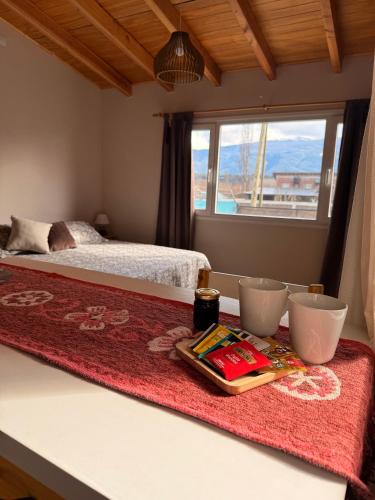 a bedroom with a bed and a table with two bowls at Apart Patagonia Bolson in El Bolsón