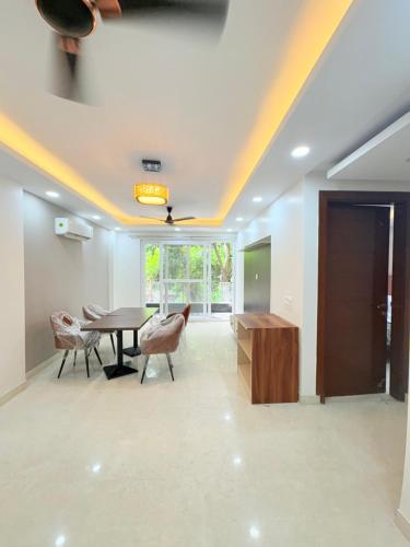 a dining room with a table and chairs and a ceiling at The Nuvon Residency CR Park in New Delhi