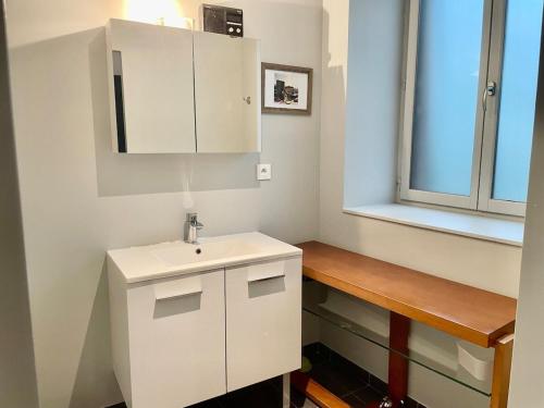 a white bathroom with a sink and a window at Le Retro & Pierres Dorées in Le Bois-dʼOingt