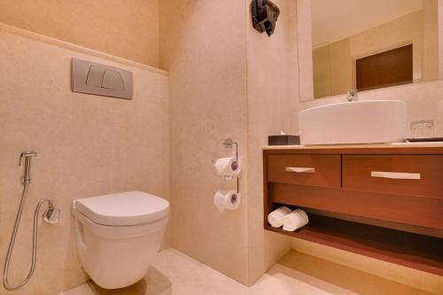 a bathroom with a toilet and a sink at Hotel NYSA Benzo Plaza Near Delhi Airport in New Delhi