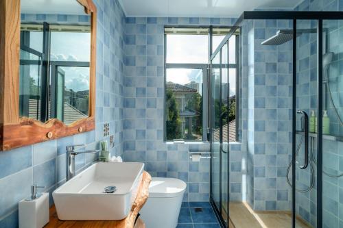 a bathroom with a toilet and a sink at Floral Hotel Tengchong Wuwenju B&B in Tengchong