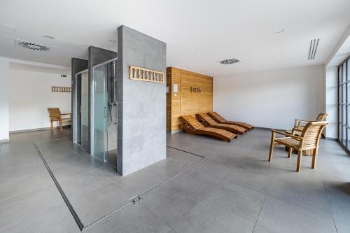 a living room with a couch and a table and chairs at Wellness apartmán Pila Kvilda in Kvilda