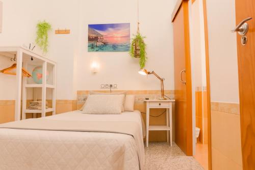 mała sypialnia z łóżkiem i biurkiem w obiekcie Aire Hostal en Los Alcores w mieście El Viso del Alcor