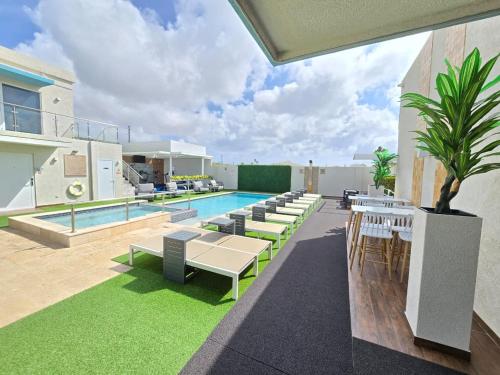an outdoor patio with a pool and tables and chairs at Aruba Boutique & Art Hotel - Adults Only in Palm-Eagle Beach