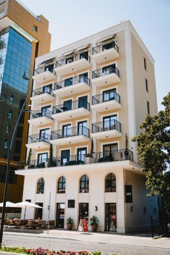 a large white building with balconies on a street at Kondo Hotel Allure in Budva