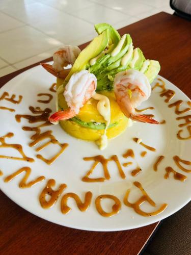 a plate with shrimp and vegetables with a happy new year message at Las cabañas de Bonanza in Zorritos
