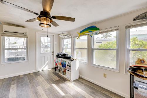 a living room with a ceiling fan and windows at Fish and Boat On-Site! Waterfront Florida Keys Home in Duck Key