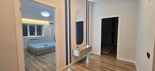 Cette chambre comprend un miroir et un lit. dans l'établissement Жк Кербез, à Aktau