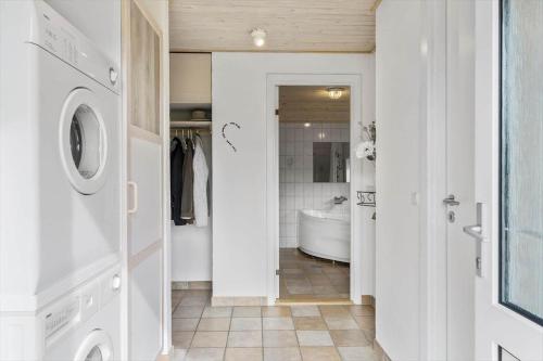 uma casa de banho branca com uma banheira e uma máquina de lavar roupa em 40812-Ulfborg-Helmklit-214 em Fjand Gårde