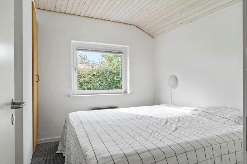 um quarto branco com uma cama e uma janela em 40812-Ulfborg-Helmklit-214 em Fjand Gårde