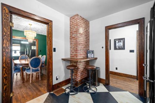 a living room with a brick fireplace and a table and chairs at The Pink and Old Clarksville House - Alpha Link Homes in Clarksville