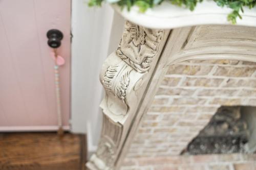 a fireplace with a white mantel next to a brick fireplace at The Pink and Old Clarksville House - Alpha Link Homes in Clarksville