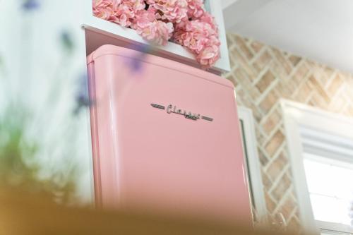 a pink suitcase with a pen on top of it at The Pink and Old Clarksville House - Alpha Link Homes in Clarksville