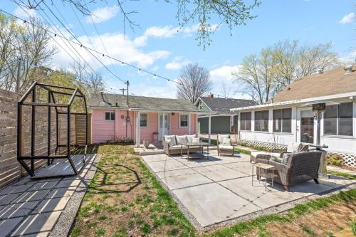 a house with a patio with chairs in the yard at The Pink and Old Clarksville House - Alpha Link Homes in Clarksville