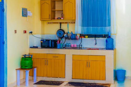 a kitchen with wooden cabinets and a green appliance at The Homely Retreat in Thika