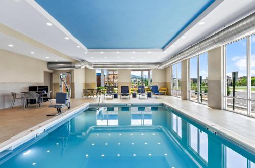 a pool with blue water in a building with windows at Hampton Inn Daleville in Daleville