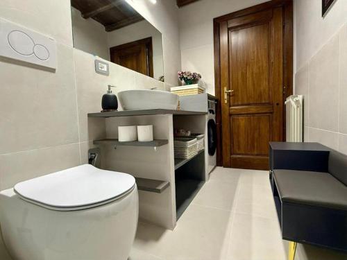 a bathroom with a white toilet and a sink at Casa del Lago in Monterosi