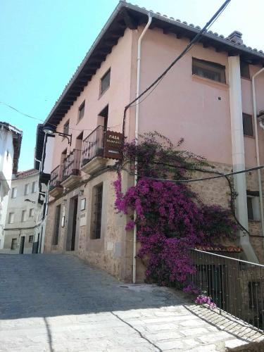 a building with purple flowers on the side of it at Apartamentos Rurales La Lancha in Aldeanueva de la Vera