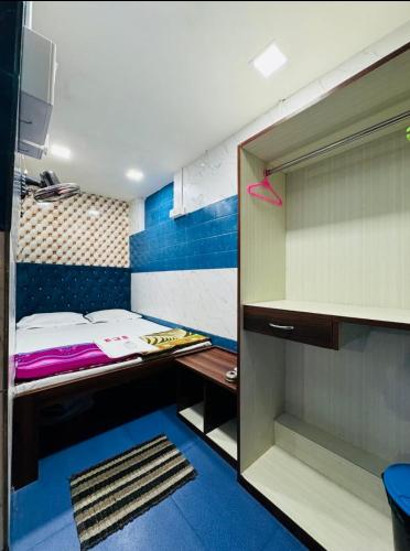 a small room with a bed and a desk at RR Guest House in Kolkata