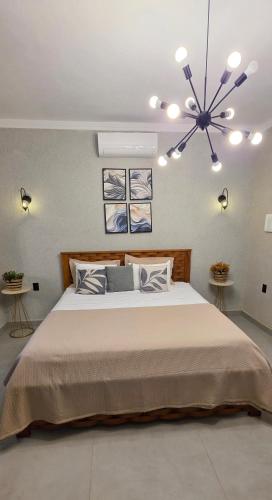 a bedroom with a large bed with a chandelier at Pousada Lago Azul in Delfinópolis