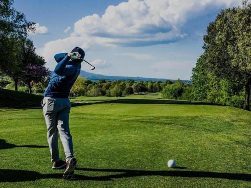 a man swinging a golf club on a golf course at Casa del Lago in Monterosi