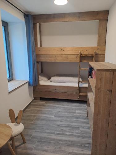a room with two bunk beds and a desk at Au pied de La Redoute in Sougné-Remouchamps
