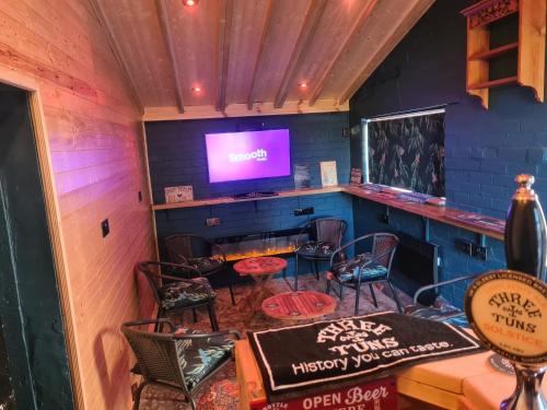 a bar with a table and chairs and a tv at Upper Eyton Farmhouse B&B in Shrewsbury