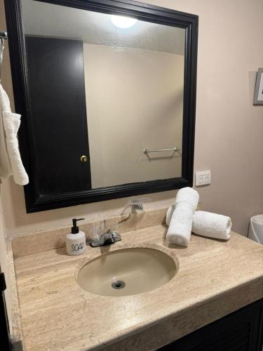 a bathroom sink with a large mirror above it at Apartaestudios - Torre de Cali in Cali