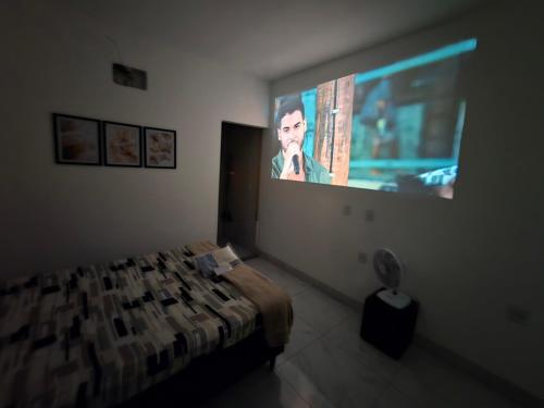 a bedroom with a bed and a tv on the wall at Flat completo 11 minutos do centro de Aparecida de Goiania in Aparecida de Goiania