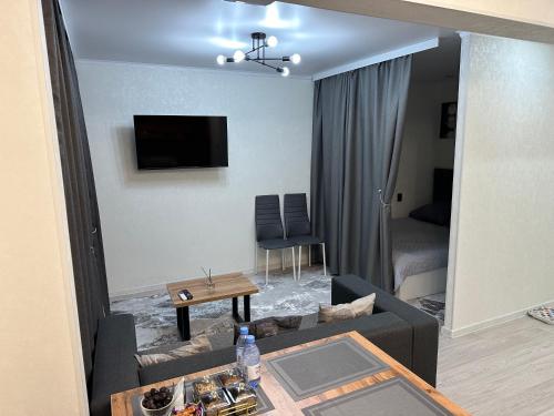 a living room with a couch and a table at Однокомнатная квартира посуточно Люкс in Balqash