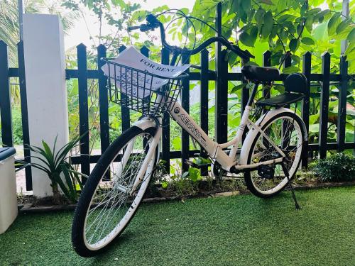 a bike parked next to a fence with an umbrella at AHK Homestay 1 in Phu Quoc