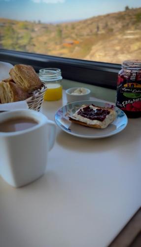 Una mesa con un plato de pan y una taza de café. en Cuesta de las Piedras, en La Cumbrecita