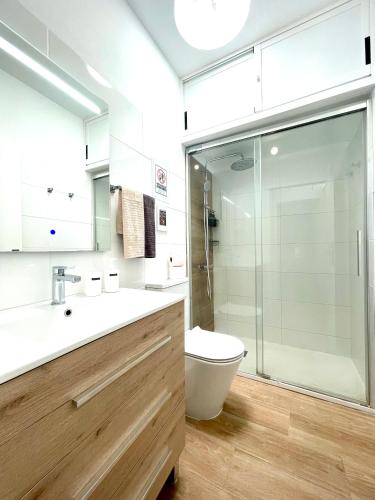 a bathroom with a toilet and a glass shower at Apartamento D&L in Costa Del Silencio