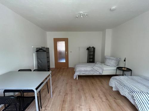 a white room with two beds and a wooden floor at Monteurwohnung I Wi-Fi I Nähe Boxberg & Schwarze Pumpe in Burgneudorf