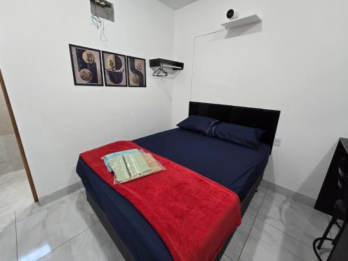 a bedroom with a bed with a red blanket at Flat completo 12 minutos do centro com lojas variadas in Aparecida de Goiania