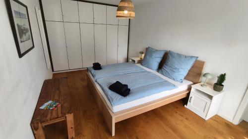 a bedroom with a bed with a black cat sitting on it at Ferienhaus Fringaluna in Übersee