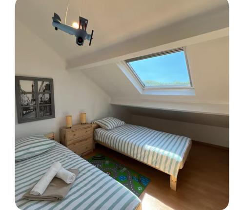 two beds in a room with a window at Villa familiale piscine proche de Paris in Antony
