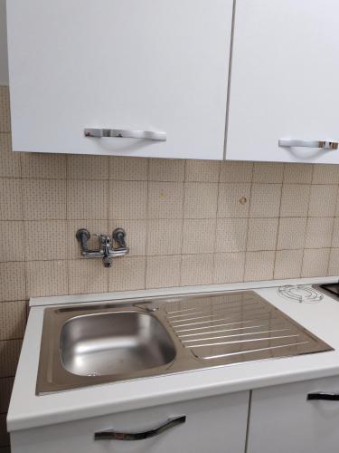 a kitchen with a sink and white cabinets at Casa ALFRED FIDENZA in Fidenza
